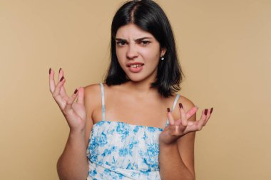 Bej arka planda kafası karışmış genç bir kadın..