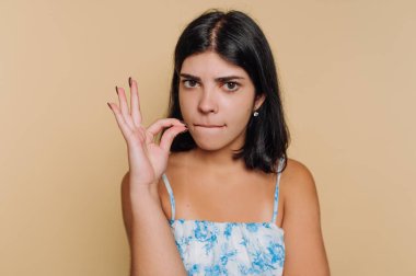 Genç bayan ciddi bir ifadeyle iyi bir jest yapıyor.
