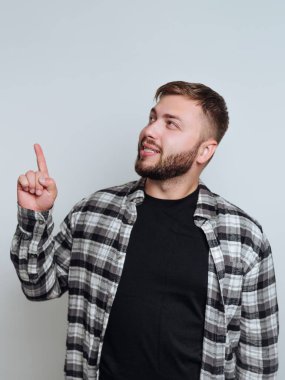 Ekose gömlekli adam, düşünceli bir ifadeyle yukarıya bakıyor..