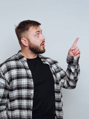 Ekose gömlekli adam arka planda yukarıya bakıyor..