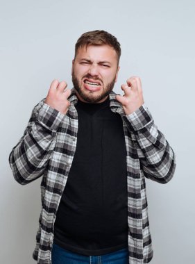 Ekose gömlekli, yumruklarını sıkan hayal kırıklığına uğramış bir adam..