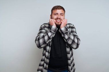 Ekose gömlekli adam endişeli görünüyor..