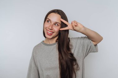 Gülümseyen kadın parmaklarıyla barış işareti yapıyor..