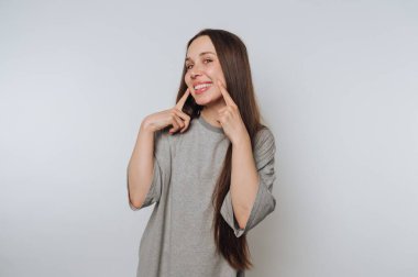 Gülümseyen kadın arka planda yanaklarını gösteriyor..