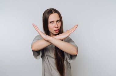 Uzun saçlı bir kadın kollarıyla X yapıyor, reddediyor..