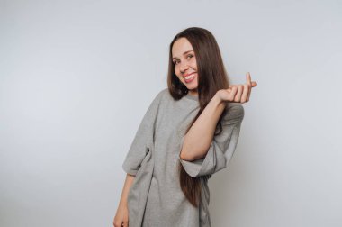 Gri kazaklı, neşeli yüzlü bir kadın.