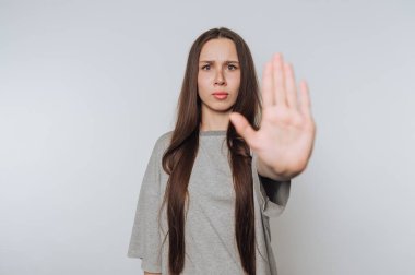 Uzun saçlı bir kadın elleriyle jest yapıyor..