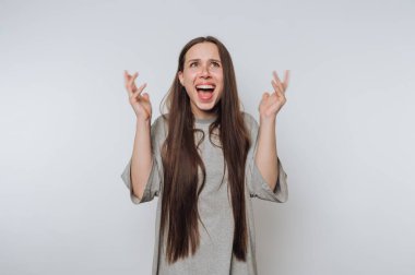 Uzun saçlı bir kadın heyecan ve şaşkınlık ifade ediyor..