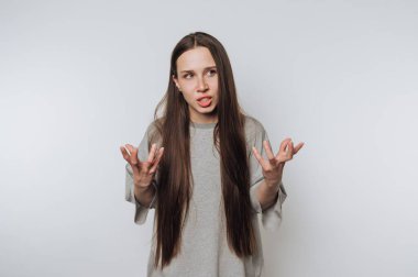 Uzun saçlı genç kadın kafa karışıklığı ve hayal kırıklığını ifade ediyor..