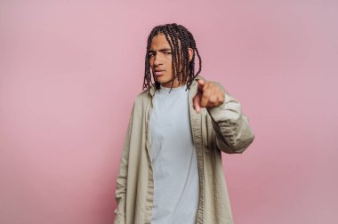 Pembe arka planda öne doğru örülmüş saçları olan genç bir adam..