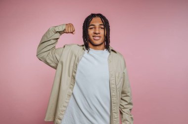 Pembe arka planda kollarını esneten genç biri..