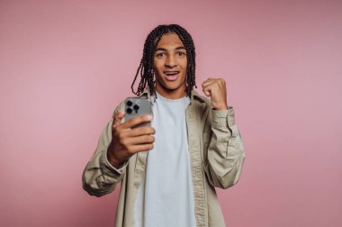 Genç adam başarıyı akıllı telefonuyla kutluyor..