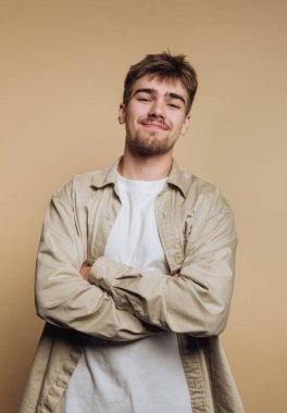 Kendine güvenen bir gülümsemesi ve bej bir geçmişi olan genç bir adam..