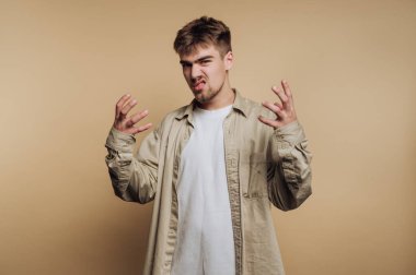 Genç adam bej arka planda elleri kaldırarak hayal kırıklığını ifade ediyor..