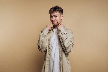 Günlük kıyafetli, gülümseyen ve gülümseyen genç bir adam..