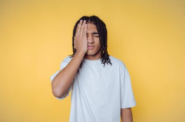 Sarı arka planda eli yüzü olan genç adam.