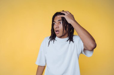 Sarı arka planda rastalı genç bir adam.