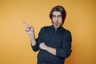 Turuncu arka planda uzun saçlı genç adam..