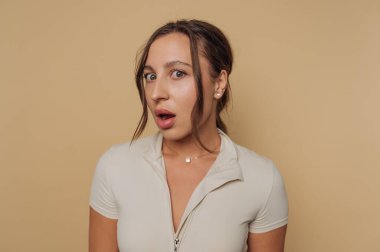 Bej arka plana karşı şaşırmış bir kadın