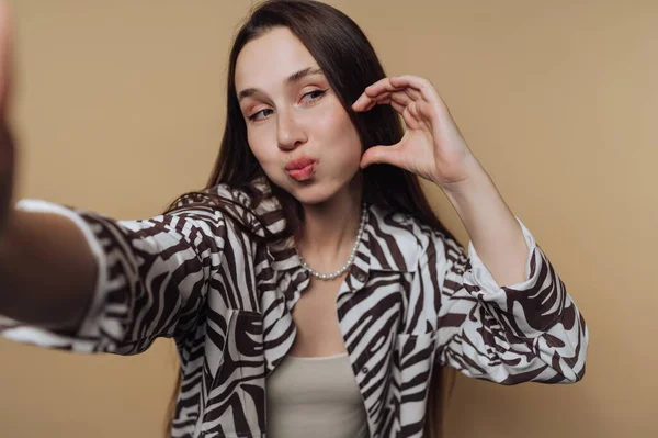 Genç bir kadın neşeli bir ifadeyle selfie çekiyor..