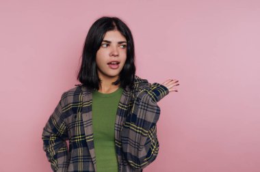 Genç bir kadının portresi neşeyle, şaşkınlık ifadesiyle, pembe arka planda bir mizah duygusunu aktarıyor.