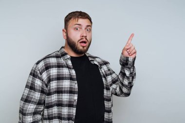 Şok olmuş bir ifadeyle şaşırmış genç bir adamın portresi beyaz arka plandaki şaşkınlığı ya da farkındalığı işaret ediyor.