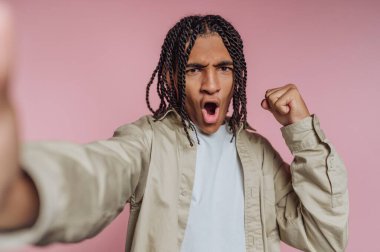 Örgülü saçlarıyla kutlama yapan genç bir adam..