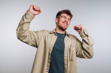 Genç adam yumruklarıyla kutluyor, gündelik kıyafetler giyiyor..