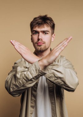 Bej arka planda çapraz kollu genç adam..