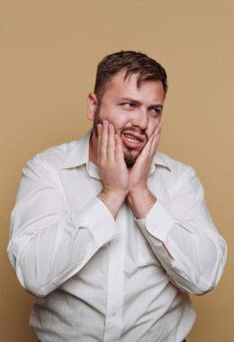 Beyaz gömlekli bir adam hayal kırıklığını ifade ediyor..