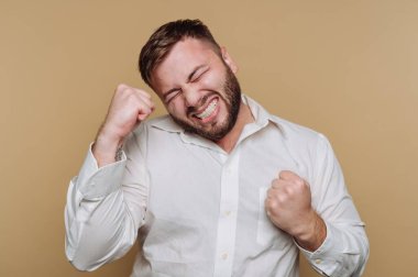 Beyaz gömlekli bir adam heyecanını yumruklarıyla ifade ediyor..