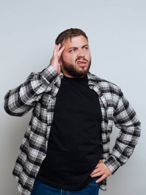 Ekose gömlekli adam kafası karışmış görünüyor, elleri başının üstünde..