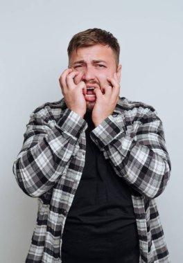 Ekose gömlekli bir adam korku ve endişe ifade ediyor..