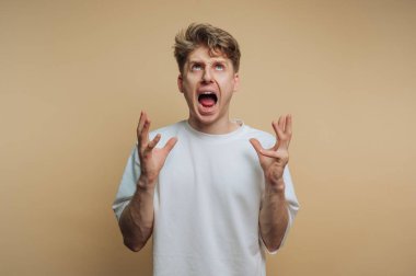 Beyaz gömlekli genç bir adam hayal kırıklığı ya da kızgınlığını dile getiriyor..