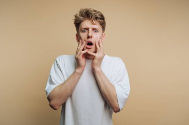 Suratı asık, bej rengi geçmişi olan genç bir adam..