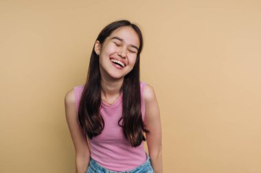 Bej arka planda gülen genç bir kadın..