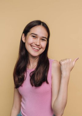 Sarı bir duvara yaslanmış, gülümseyen ve baş parmağını kaldıran bir insan. Ayarlar rahat ve rahat görünüyor, bu da mutlu bir anı işaret ediyor..