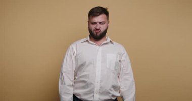 Sarı arka planda bir adam duruyor. Komik bir ifade takınıyor ve bu anın tadını çıkarıyor. Giysileri sıradan ve basit..