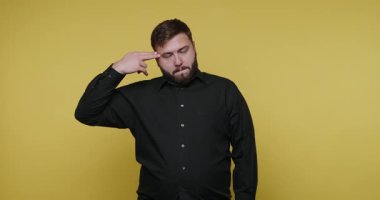 Bir adam parlak sarı bir arkaplan önünde işaret dilini icra ediyor. Seyircilere duygularını ve mesajlarını açıkça iletmek için çeşitli jestler yapıyor. Ayarlar tamamen onun hareketlerine odaklanıyor..