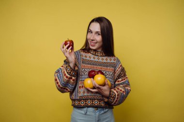 Sarı arka planda elma tutan kadın..