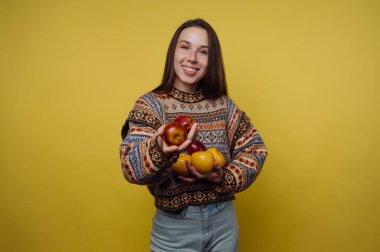 Sarı arka planda elma tutan kadın.