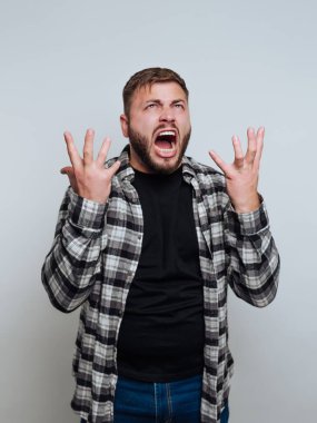 Ekose gömlekli bir adam hayal kırıklığını elleriyle ifade ediyor..