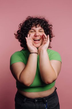 Kıvırcık saçlı, yeşil bluzlu ve bağıran neşeli biri..