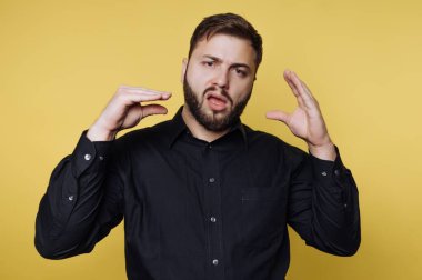 Kendinden emin bir birey parlak sarı bir arka plana karşı duruyor, tutkulu bir şekilde el hareketleriyle fikirleri paylaşıyor. Yüz ifadeleri coşku ve bağlılığı ifade ediyor..