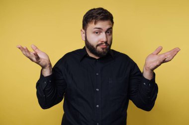 Bir adam kendine güveni tam bir şekilde duruyor, omuzlarını silkiyor ve sıradan bir hareketle ellerini kaldırıyor. Canlı sarı arkaplan sahneye enerjik ve canlı bir hava katıyor..