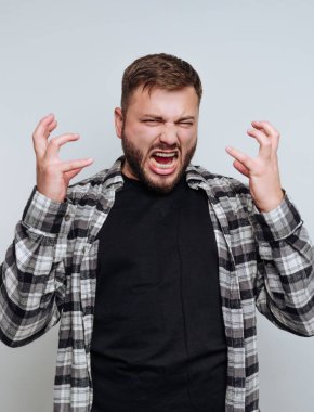 Gündelik giyinmiş genç bir adam yoğun duygular gösterir. Ellerini tutarken zorla bağırır. Yüzü, basit, nötr bir ortamda saf duyguları açığa çıkarıyor..