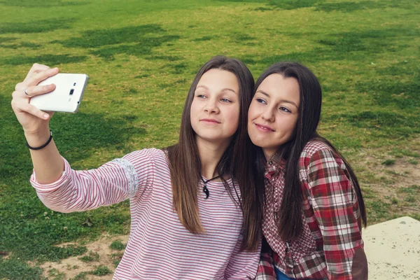 Duas meninas são fotografadas pelo telefone celular — Fotografia de Stock