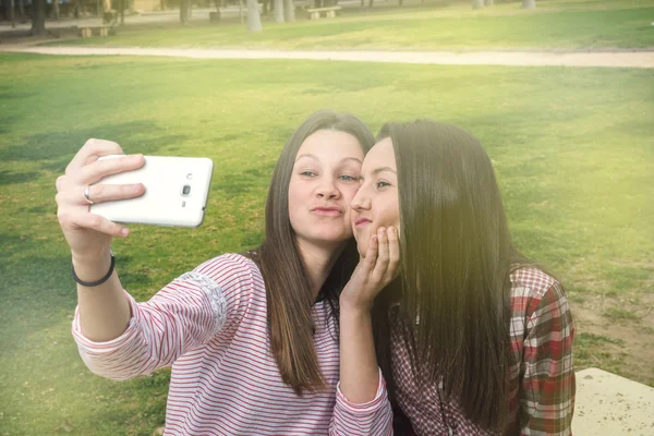Dwie dziewczyny są fotografowane przez telefon komórkowy — Zdjęcie stockowe