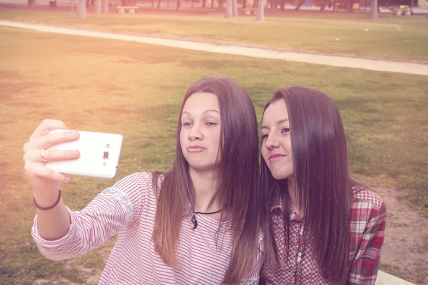 Duas meninas são fotografadas pelo telefone celular — Fotografia de Stock