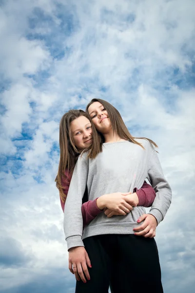 Twee meisjes tegen de hemel — Stockfoto